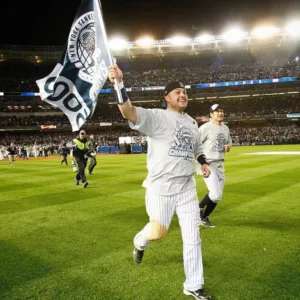 Nick Swisher holding a New York Yankees flag while running on field
